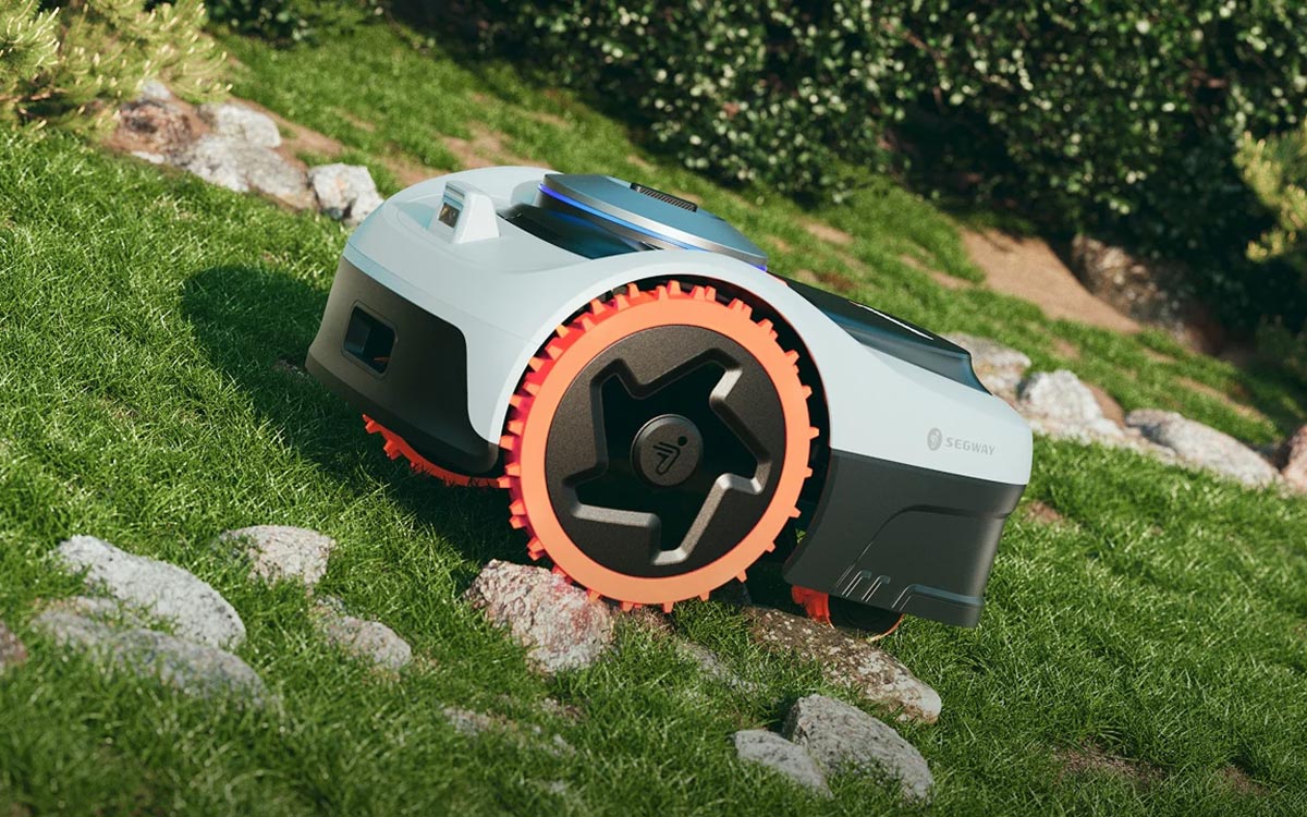 Robot tondeuse Segway Navimow i2 AWD en pleine tonte sur une pelouse en forte pente.