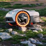 Robot tondeuse Segway Navimow i2 AWD franchissant des racines et un terrain irrégulier.