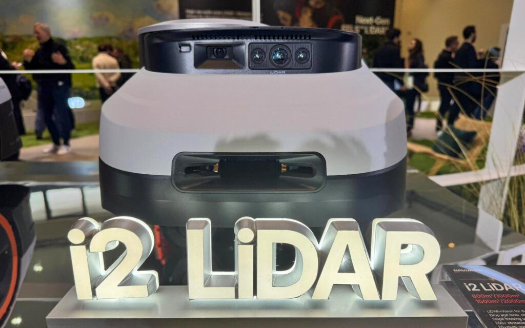 Vue de face du robot tondeuse Navimow montrant l'objectif de la caméra grand angle et le capteur LiDAR central.