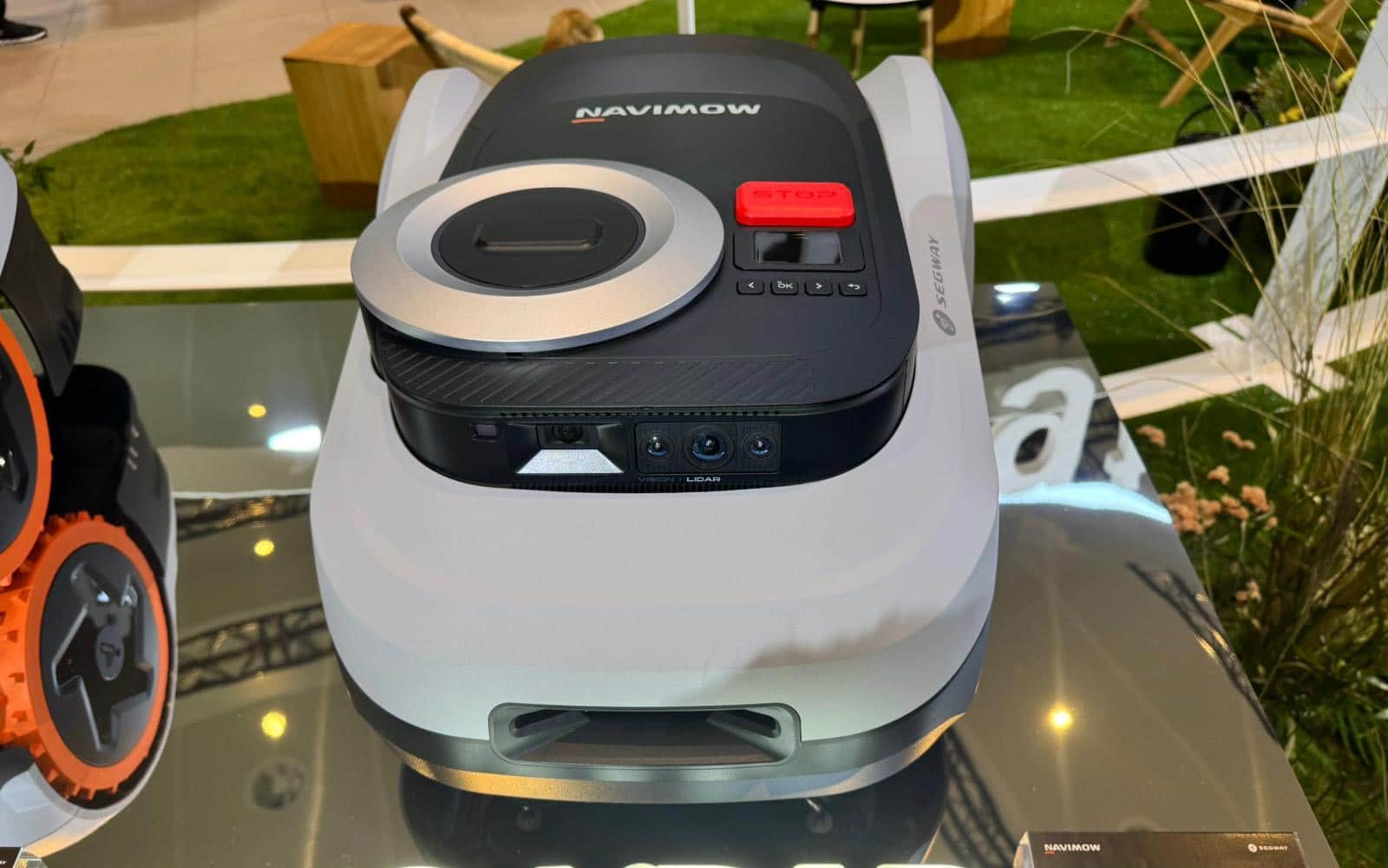 Robot tondeuse Segway Navimow i220 LiDAR vu du dessus montrant son carter compact noir et son écran de contrôle