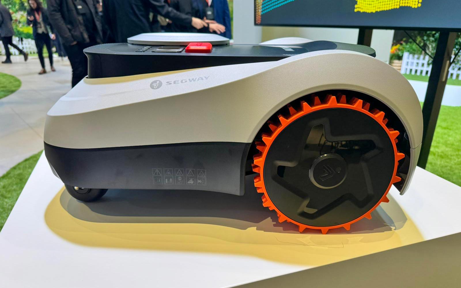 Gros plan sur une roue arrière tout-terrain à crampons du robot Navimow avec mécanisme de suspension visible