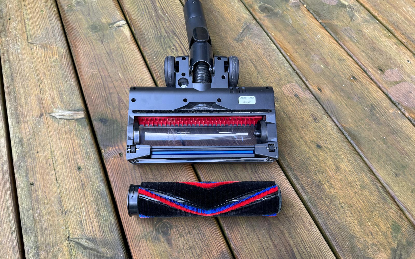 Rouleau de brosse amovible posé à côté de la tête d'aspiration du Tineco A90S.
