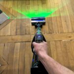 Vue de dessus de l'aspirateur balai Tineco Pure One A90S utilisé sur un parquet en bois.