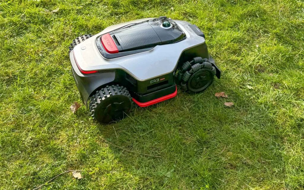 Robot tondeuse 4x4 Dreame A3 AWD Pro 5000 avec roues Mecanum sur une pelouse en pente.