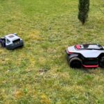 Trois robots tondeuses sans fil (Dreame A3 AWD Pro 5000, Ecovacs GOAT A1600 LiDAR PRO et Anthbot M9) alignés sur une pelouse lors d'un test comparatif.