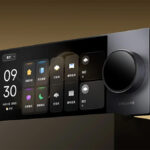 Image promotionnelle de l'écran de contrôle intelligent mural Dreame Smart Control Screen S6, suspendu au-dessus d'une surface texturée. L'appareil est de couleur gris métallisé.