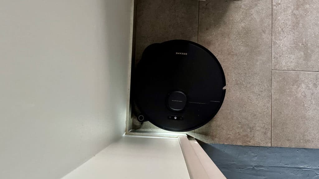 Dreame L50S Pro Ultra vu de dessus, calé dans un angle de la pièce contre la plinthe
