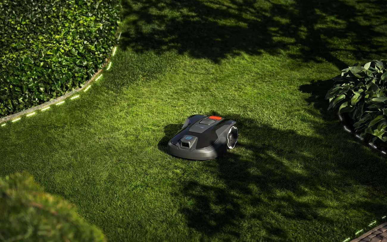 Husqvarna Automower 308V en fonctionnement sur une pelouse avec indication de ses performances de tonte