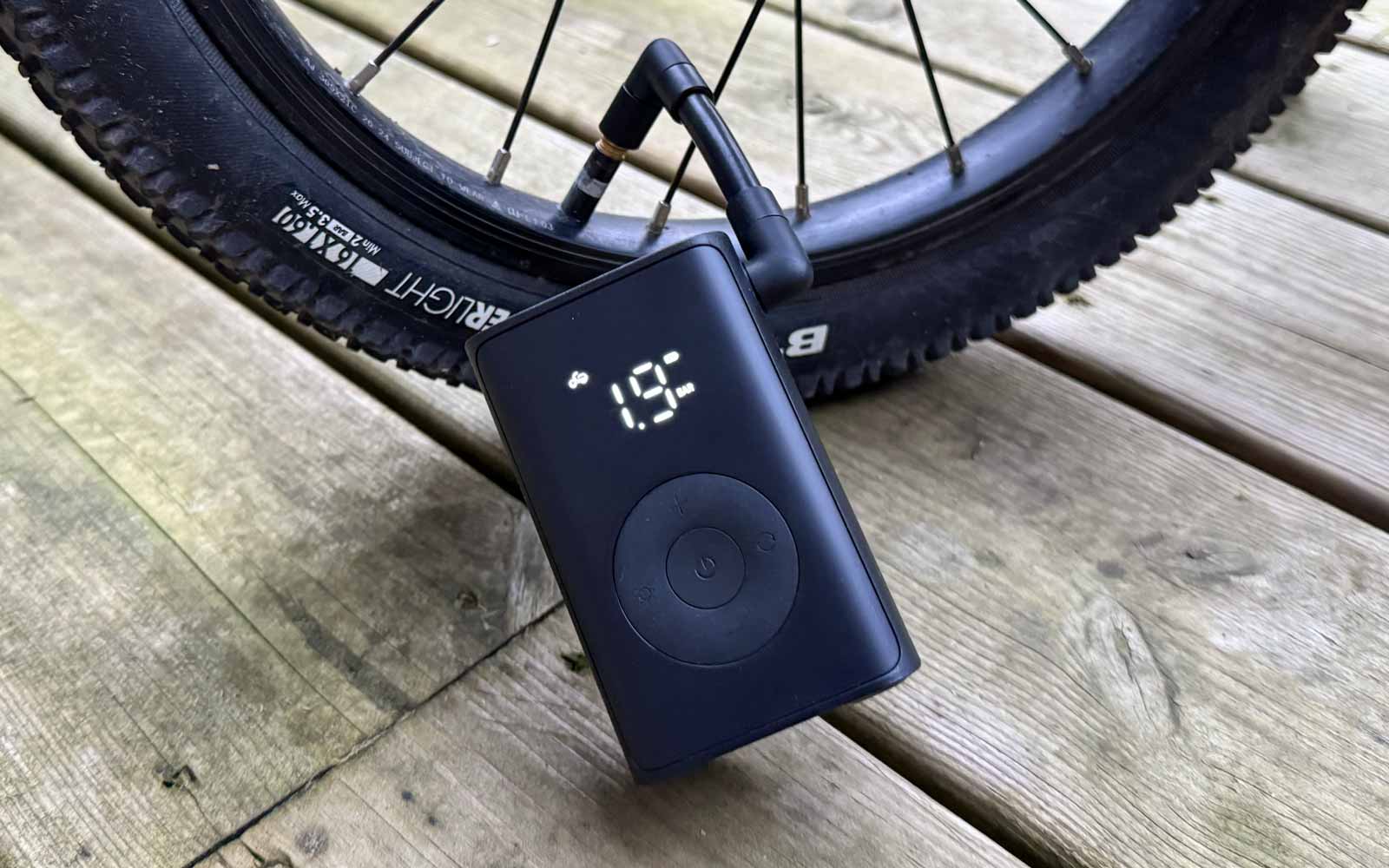 Compresseur Xiaomi Mijia Compact en train de gonfler le pneu d’un vélo d’enfant pendant le test