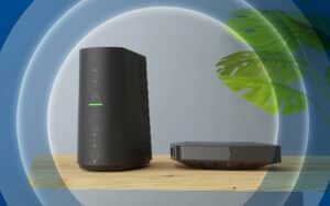 Une Bbox de Bouygues Telecom et son décodeur TV posés sur un meuble en bois avec une plante en arrière-plan, illustrant l'augmentation des tarifs.