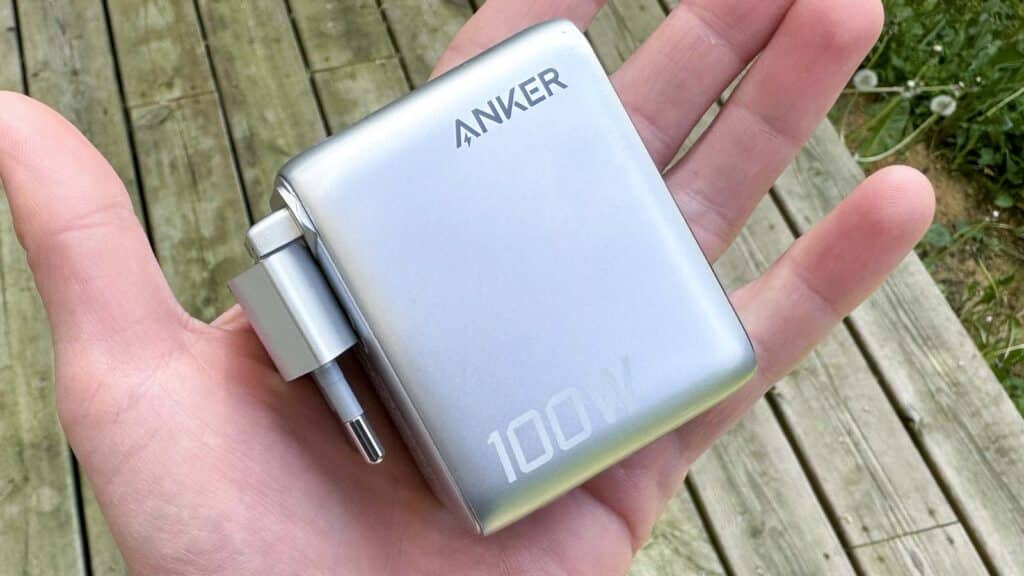 chargeur Anker 100W tenu en main montrant son format compact et transportable