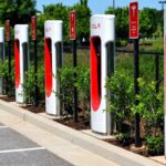 Station de Superchargeurs Tesla sur une aire d'autoroute, un point de recharge essentiel pour les départs en vacances en voiture électrique.