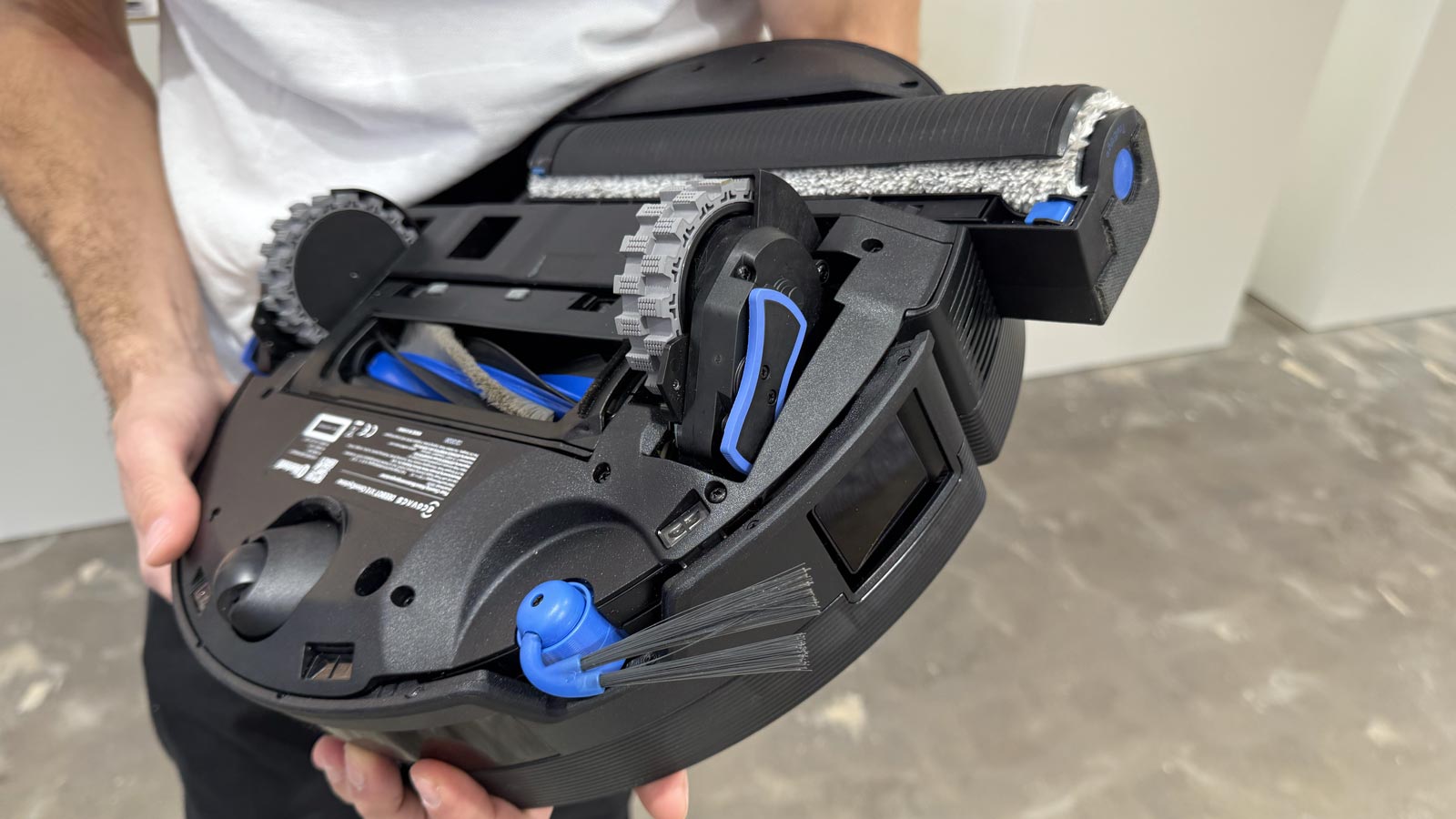 Dessous du Deebot X12 avec rouleau laveur, clapet de protection des tapis et décalage latéral pour longer les murs