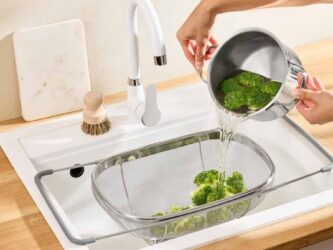 Passoire d'évier Lidl en acier inoxydable positionnée au-dessus du bac pour égoutter des brocolis.
