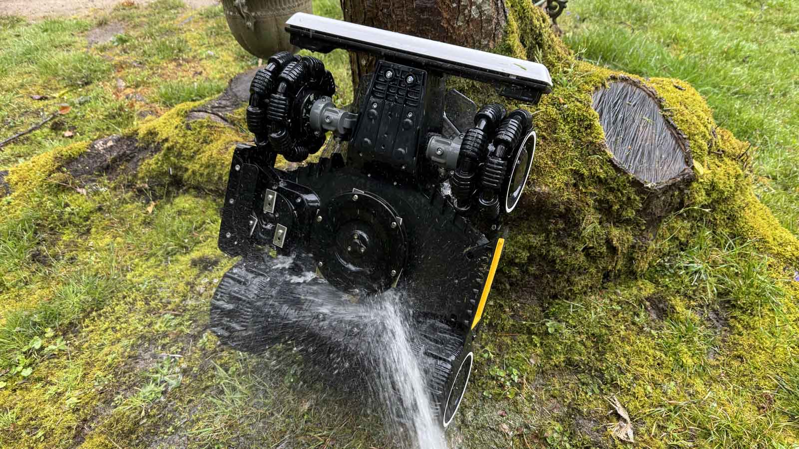 Nettoyage des lames du Luba Mini 2 AWD au jet d’eau sur la pelouse