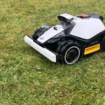 Robot Luba Mini 2 AWD à l’arrêt devant une grosse touffe d’herbe