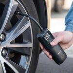 Mini compresseur d'air portatif Dunlop en train de gonfler un pneu de voiture
