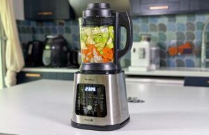 Blender chauffant Moulinex Perfectmix Cook avec légumes crus dans le bol en verre pendant un programme soupe