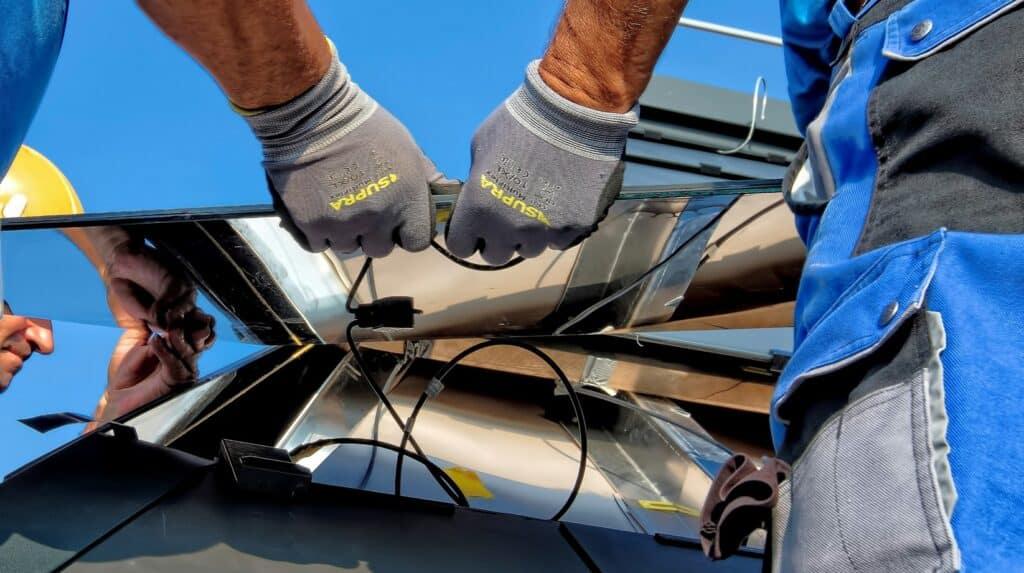 Deux individus en train de poser des panneaux solaires