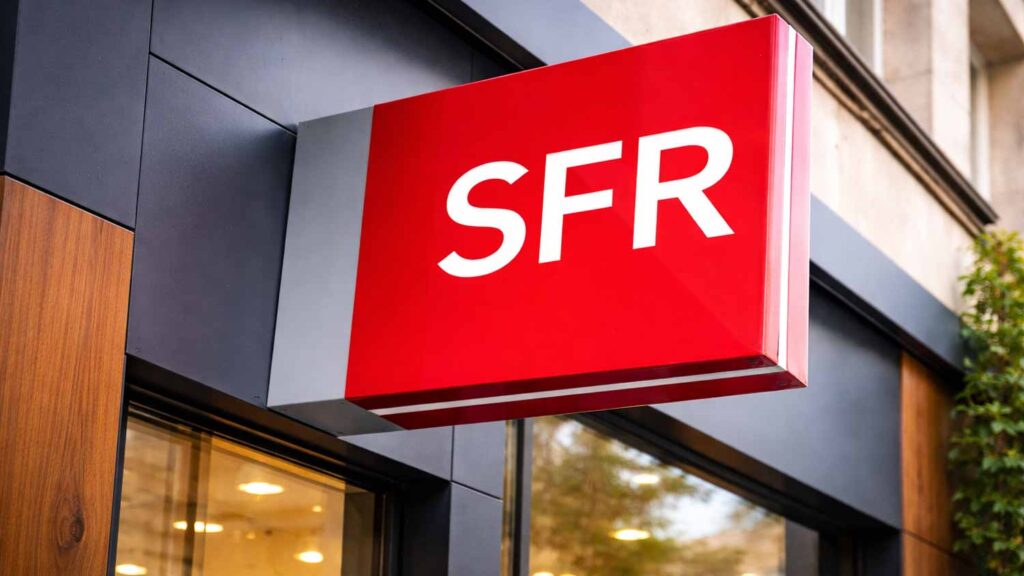 Enseigne rouge avec le logo SFR sur la façade d'une boutique, symbolisant le rachat de l'opérateur par Orange, Free et Bouygues Telecom