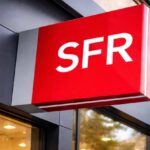 Enseigne rouge avec le logo SFR sur la façade d'une boutique, symbolisant le rachat de l'opérateur par Orange, Free et Bouygues Telecom