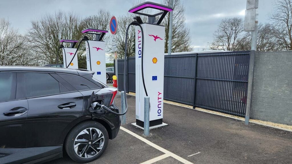 Voiture électrique branchée à une borne de recharge rapide Ionity sur une aire d'autoroute.