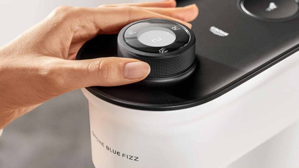 Utilisateur tournant la molette de la Grohe Blue Fizz Premium pour ajuster le niveau de gazéification de l'eau.