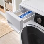 Lave-linge avec le compartiment à lessive ouvert après un cycle de lavage.