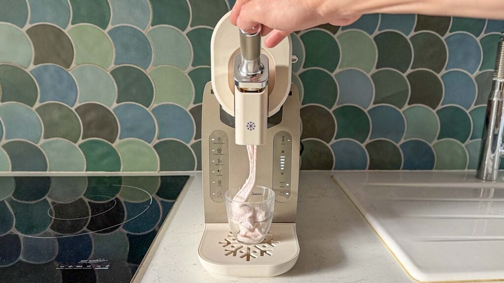 Machine Moulinex Freezi vue de face en train de servir une glace à l’italienne dans un verre