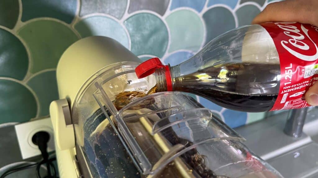 Remplissage du réservoir de la Moulinex Freezi avec une bouteille de Coca-Cola pour réaliser un granité.