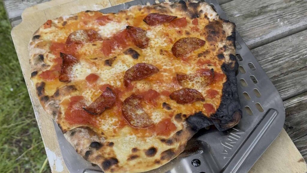 Pizza cuite dans le four à pizza Ninja Artisan posée sur la pelle à pizza