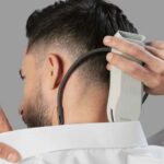 Homme plaçant le mini climatiseur portable Sony Reon Pocket Pro Plus sur sa nuque pour se rafraîchir.