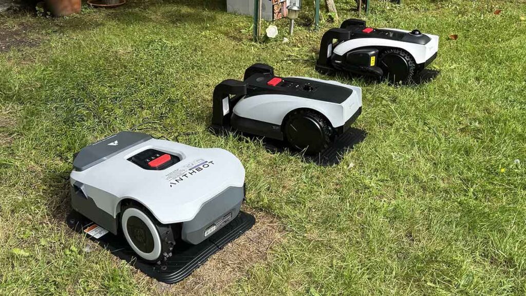 Robots tondeuses Anthbot Genie 800, Ecovacs Goat O600 RTK et O1200 LiDAR Pro alignés côte à côte lors de nos tests au labo