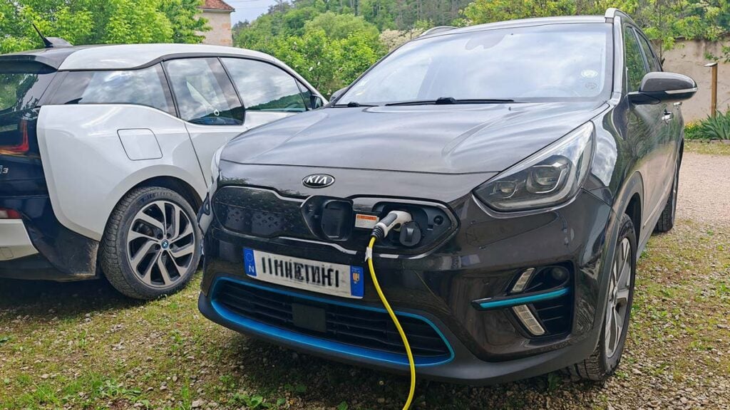Véhicule électrique en cours de recharge sur une borne murale installée à domicile.
