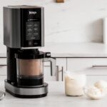 Ninja CREAMi NC300EU sur un plan de travail avec desserts glacés maison