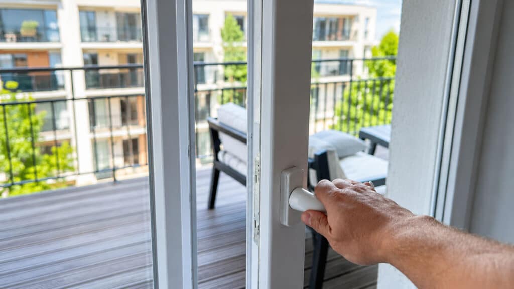 Ouverture d’une fenêtre tôt le matin pour rafraîchir un logement sans climatisation