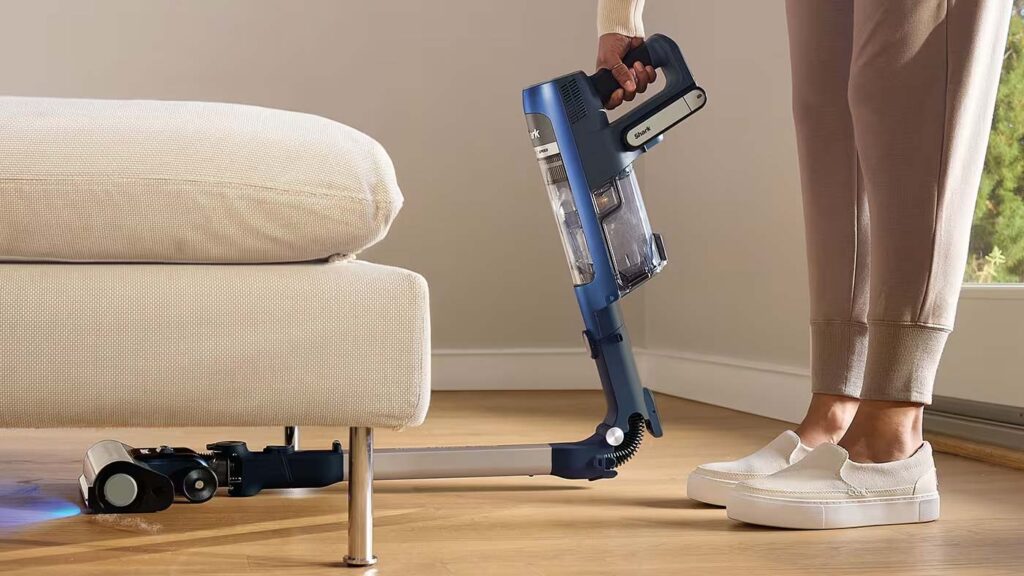 Aspirateur sans fil Shark PowerDetect utilisant son manche flexible pour nettoyer sous un meuble