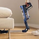 Aspirateur sans fil Shark PowerDetect utilisant son manche flexible pour nettoyer sous un meuble