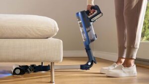 Aspirateur sans fil Shark PowerDetect utilisant son manche flexible pour nettoyer sous un meuble