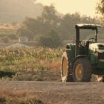 Tracteur agricole dans un champ : l'épandage d'engrais phosphatés est la principale source de contamination des sols français au cadmium.