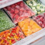 Fruits et légumes surgelés rangés dans un tiroir de congélateur