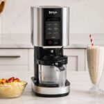Machine à glace Ninja CREAMi posée sur un plan de travail avec desserts glacés