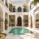 Intérieur lumineux d’un riad avec patio central, bassin et décoration d’inspiration marocaine