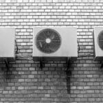 Unités extérieures de climatiseurs installées sur un mur en briques