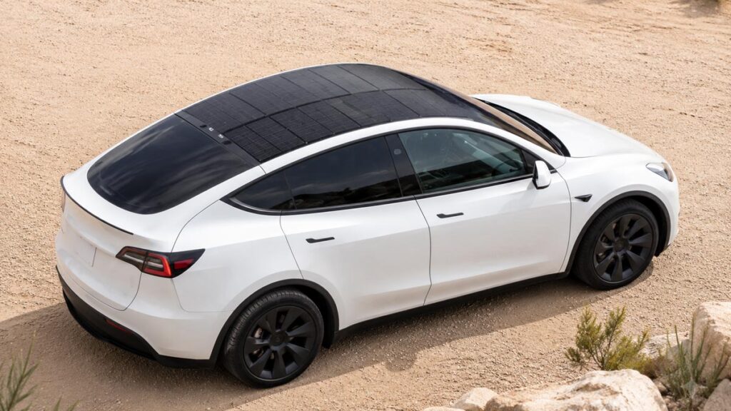 Tesla Model Y blanche équipée d’un panneau solaire sur son toit panoramique.