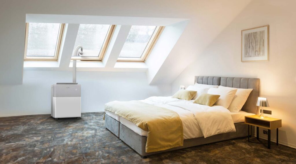 Midea PortaSplit installé dans une chambre sous combles avec passage par fenêtre de toit