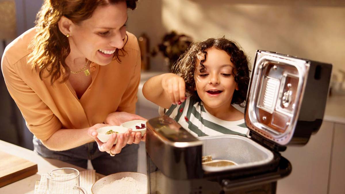 Une mère et son enfant préparent une recette avec la Panasonic SD-PMC100.