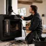 Un professionnel ramone le conduit d’un poêle à bois