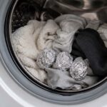 Boules de papier aluminium placées dans le tambour d’un lave-linge avec du linge