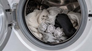 Boules de papier aluminium placées dans le tambour d’un lave-linge avec du linge